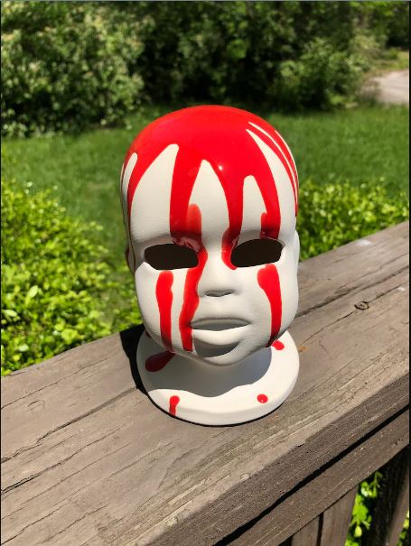 Baby head lamp with red drips over white ceramic